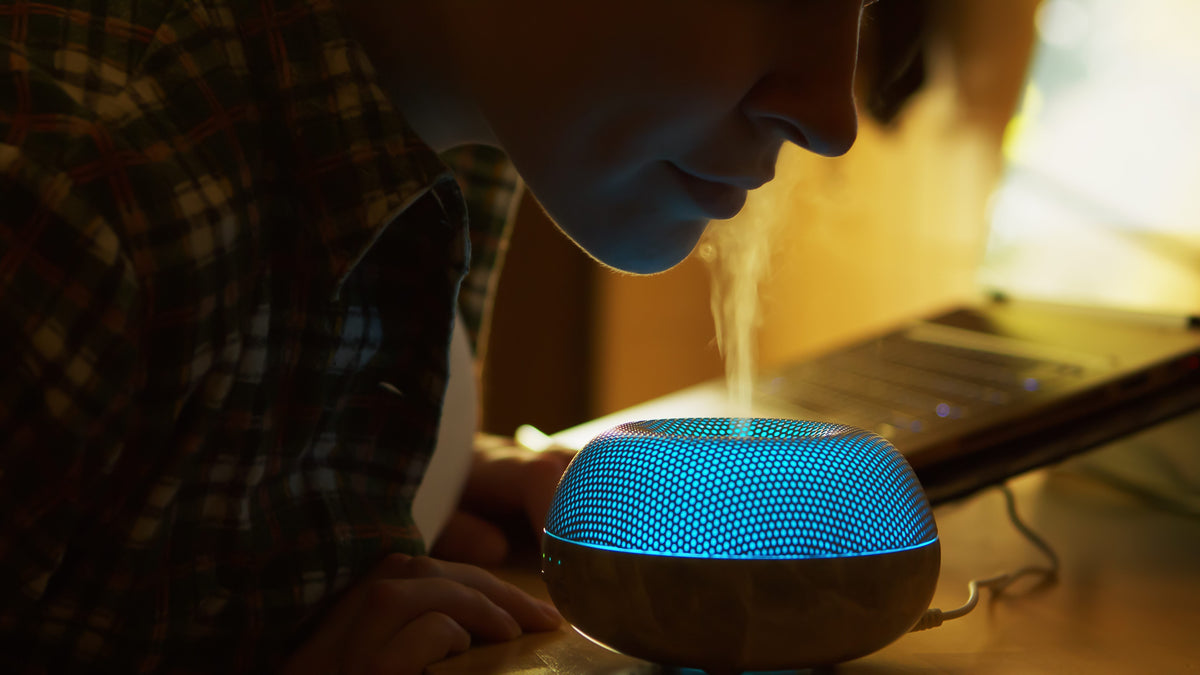 woman-inhale-aromatic-vapor-from-essential-oil-diffuser-while-working ...